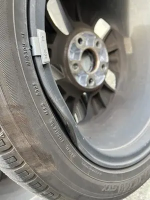 Bent aluminum alloy wheel rim lip edge showing impact flat spot