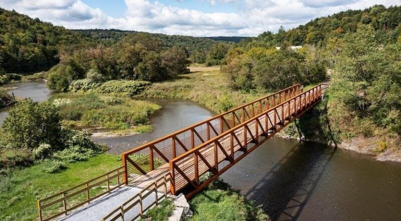 Converted iron horse rail trail and stone tunnel cutting through New England woods