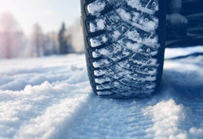 Deep tread winter tires gripping a slushy, snowblock street