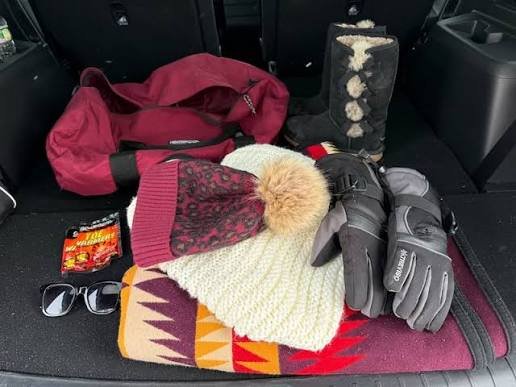 Emergency road hazard flares and insulated blankets packed safely in a trunk